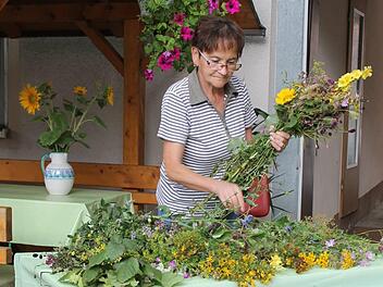 Brigitte Will zeigt, wie man einen Kräuterbuschen richtig bindet. Foto: Jupp Schröder