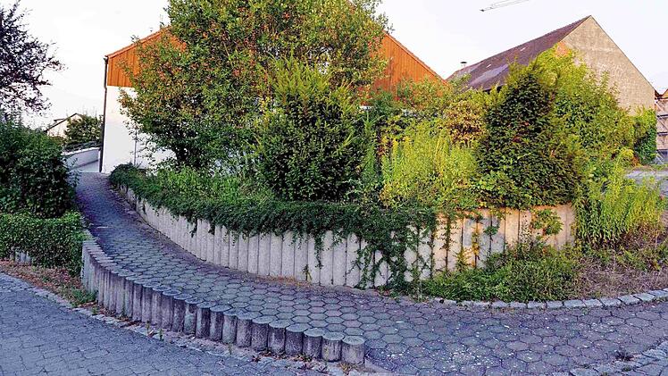 Der Boden hinter der Mauer soll für drei Parkplätze abgetragen werden, die dann direkt am barrierefreien Zugang zum Gebäude liegen. Foto: Richard Sänger