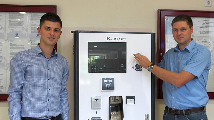 Simon Weber (links) und Konrad S&uuml;nkel am neuen Kassenautomaten: Nat&uuml;rlich wird dieser noch in schwimmbadeigenen Farben beklebt.Marieke Fiala