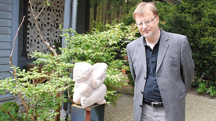 Reinhard Heinritz neben einer Skulptur von Eva Skupin.