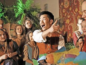 Hitoshi Tamada begeistert als junger Fischverkäufer Jamil in einer Szene mit dem Kinderchor des Landestheaters Coburg. Fotos: Henning Rosenbusch