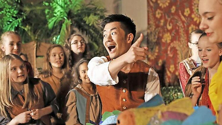 Hitoshi Tamada begeistert als junger Fischverkäufer Jamil in einer Szene mit dem Kinderchor des Landestheaters Coburg. Fotos: Henning Rosenbusch