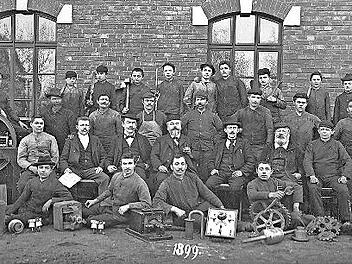 Andreas Flocken (Mitte) und die Belegschaft seiner Landmaschinenfabrik in Coburg, um 1899. Flocken entwickelte ab 1888 eins der ersten deutschen Elektroautos.