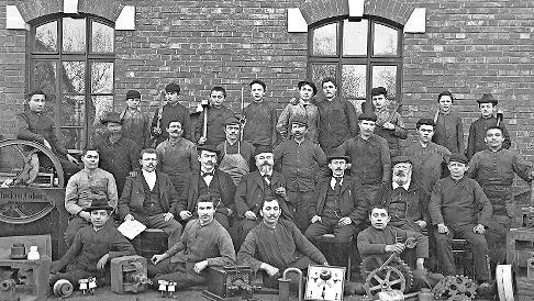 Andreas Flocken (Mitte) und die Belegschaft seiner Landmaschinenfabrik in Coburg, um 1899. Flocken entwickelte ab 1888 eins der ersten deutschen Elektroautos.