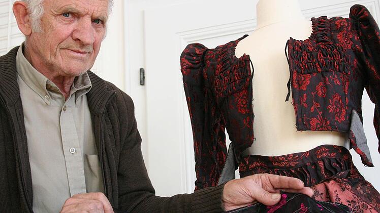 Werner Gimperlein zeigt einen Teil der Kleidungsstücke, die er dem Städtischen Museum Kitzingen geschenkt hat. Foto: Sabine Paulus