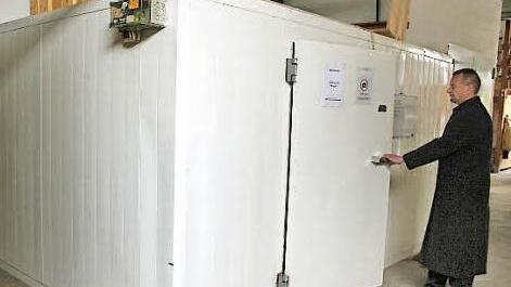 Karsten Busch betritt die Kühlkammer. Dort herrschen 5-7°, die den Verstorbenen in seinem Sarg für die Dauer bis zum Begräbnis kühlen.