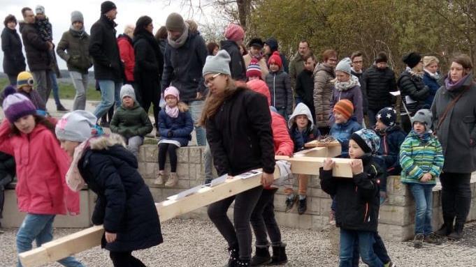 Immer wieder trugen Kinder und Eltern das Holzkreuz von Station zu Station. Foto: Günther Geiling