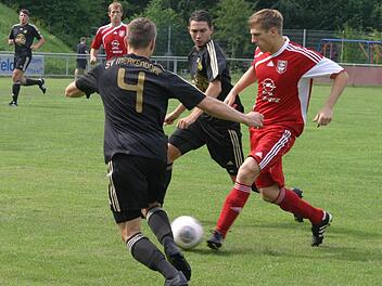 Der Eberner Ammon (rechts, rotes Trikot), Schütze des entscheidenden 2:1 in der Nachspielzeit, zieht an zwei Gegenspielern vorbei.