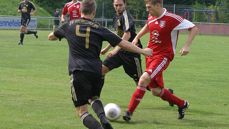 Der Eberner Ammon (rechts, rotes Trikot), Schütze des entscheidenden 2:1 in der Nachspielzeit, zieht an zwei Gegenspielern vorbei.