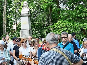 Vor dem R&uuml;ckert-Denkmal im Park der Familie, der an das Wohnhaus Friedrich R&uuml;ckerts grenzt, sangen die Teilnehmer der Wanderung das Lied "Aus der Jugendzeit" aus der Feder des Dichters. Foto: S. Hackenberg