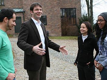 Pfarrer Heinrich Busch verwaltet den Notfond des Studienkollegs Coburg. Beatrice Mwangi (rechts), Ahmad Nazir Amani und Renata Silva Claudino freuen sich über die Unterstützung.