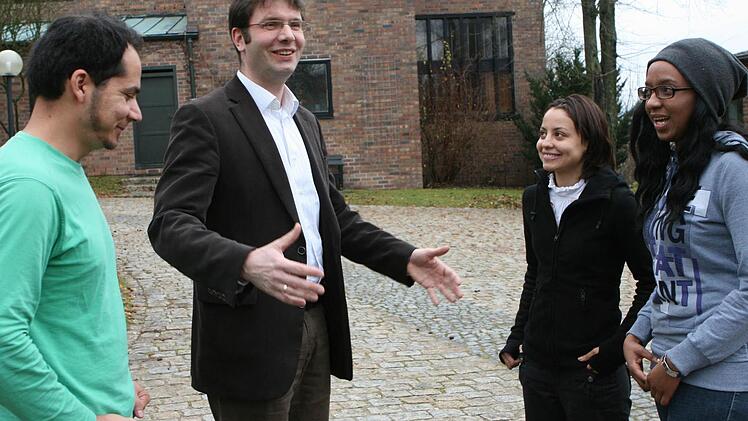 Pfarrer Heinrich Busch verwaltet den Notfond des Studienkollegs Coburg. Beatrice Mwangi (rechts), Ahmad Nazir Amani und Renata Silva Claudino freuen sich über die Unterstützung.