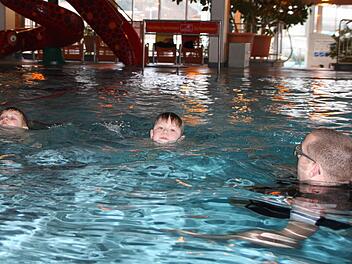 Marc (von links) und Nevio, beide sieben Jahre alt, lernen mit dem Schwimmlehrer, sich sicher im großen Becken der Therme Sinnflut zu bewegen. Foto: Ulrike Müller