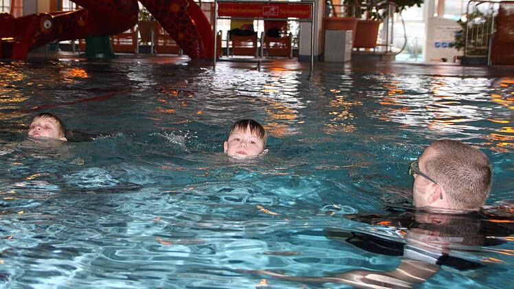 Marc (von links) und Nevio, beide sieben Jahre alt, lernen mit dem Schwimmlehrer, sich sicher im großen Becken der Therme Sinnflut zu bewegen. Foto: Ulrike Müller