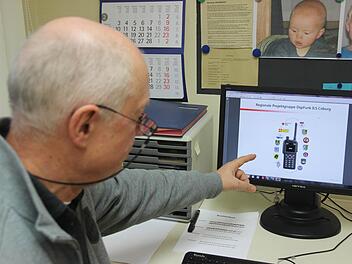 Die neue Technik immer auf dem Schirm: Klaus Langer verweist auf die Unterlagen der Regionalen Projektgruppe DigiFunk ILS Coburg. Geräte wie das dort abgebildete sind in der Region jedoch noch rar gesät, weil die Ausschreibungen dafür noch am Laufen sind. Foto: Marco Meißner