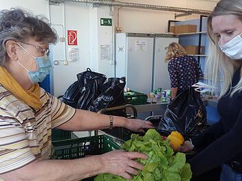 Brigitte Körner (links) und Stefanie Renner packen gemeinsam eine Tüte mit Lebensmitteln. Aus Hygienegründen können die Kunden aktuell nicht mehr in die Räume der Tafel. Sie bekommen die verpackten Rationen am Eingang ausgehändigt.  Foto: privat