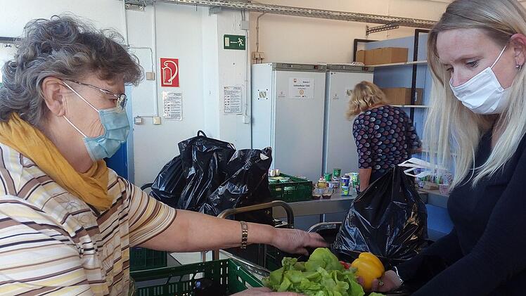 Brigitte Körner (links) und Stefanie Renner packen gemeinsam eine Tüte mit Lebensmitteln. Aus Hygienegründen können die Kunden aktuell nicht mehr in die Räume der Tafel. Sie bekommen die verpackten Rationen am Eingang ausgehändigt.  Foto: privat