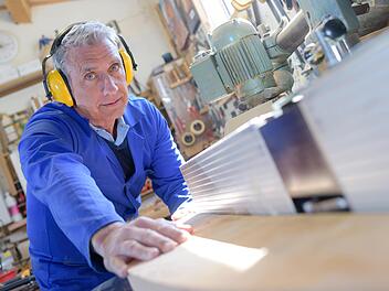 Schreiner schleift Holzmaterialien, alter Mann arbeitet