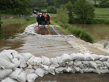 Dass die Aurach über die Ufer tritt und in die Tretzendorfer Weiher fließt, war nicht zu verhindern. Immerhin aber gelingt es den Feuerwehrleuten und anderen Helfern, die Strömungen mit Hilfe von Sandsäcken zu kontrollieren. Fotos: Sabine Weinbeer