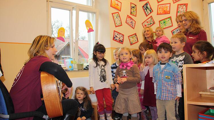 Die Kinder singen ein Lied bei der Einweihungsfeier. Leiterin Melanie Reuther begleitet sie auf der Gitarre. Foto: Archiv/ezw