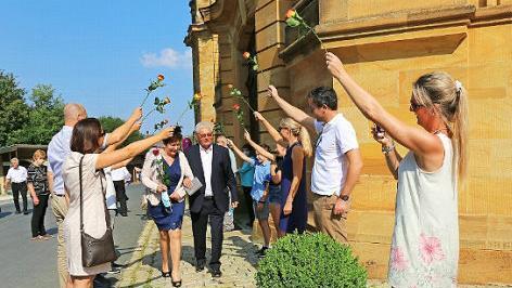 Die Familienmitglieder stehen mit Rosen in der Hand Spalier für Margot und Erwin Kühnlein aus Breitengüßbach.
