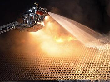 Mit Hilfe der Drehleiter musste das Feuer von oben bekämpft werden. Die Flammen schlugen aus dem Dach.  Foto: Peter Rauch