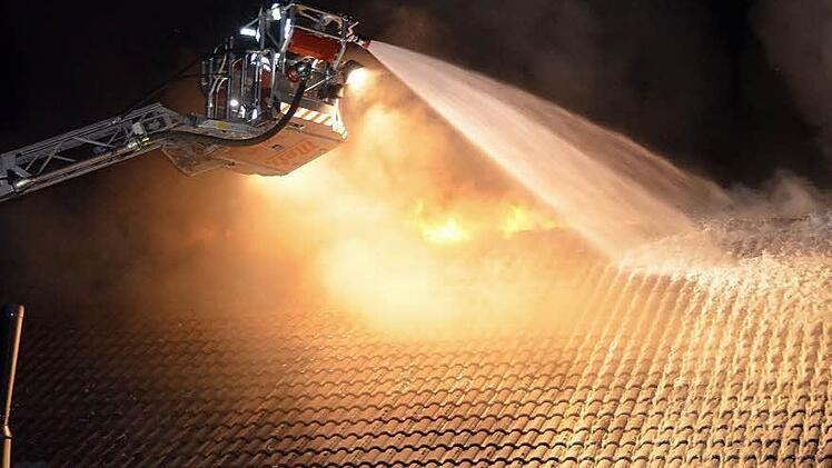 Mit Hilfe der Drehleiter musste das Feuer von oben bekämpft werden. Die Flammen schlugen aus dem Dach.  Foto: Peter Rauch