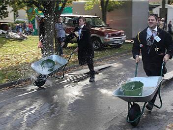 Beim Schubkarrenrennen sind Martin Köhler und Christian Kehrer  mit allem Ernst bei der Sache, auch wenn das Wasser schwappt.   Foto: G. Bauer