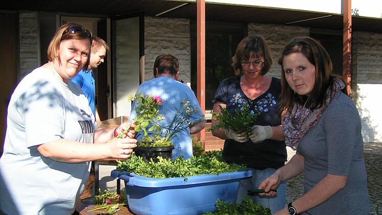 Anna Hack, Doris Reichel und Alexandra Krause (v.l.) schneiden Buchszweige für die Girlanden. Fotos: Amon