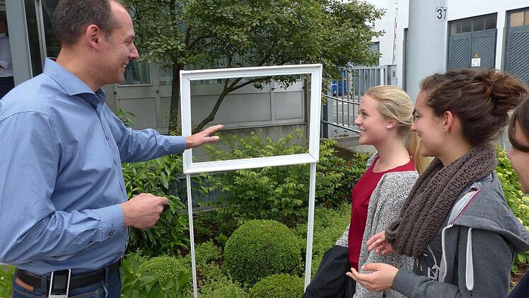 Die Studentinnen erklären Ros-Geschäftsführer Steffen Tetzlaff anhand eines aufgestellten Bilderrahmens, dass es bei Achtsamkeit darum geht, seine Umwelt bewusst wahrzunehmen. Foto: Stephan Preisz