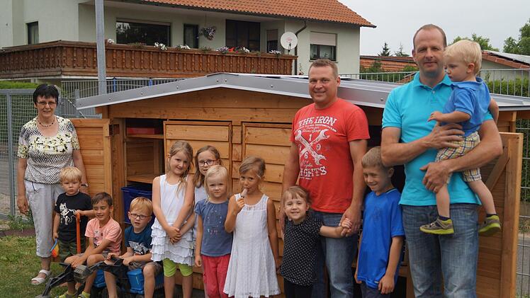 Kindergartenleiterin Maria Saal und die Kinder bedankten sich bei Hartwig Kirchner (rechts), der das Häuschen geplant und gebaut sowie bei Andreas Katzenberger, der sich um das Fundament für das Häuschen gekümmert hatte.  Foto: Manfred Mellenthin