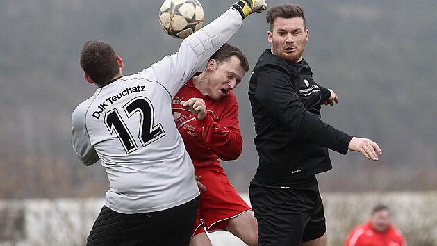Der Teuchatzer Torwart Daniel Dorsch (l.) faustet den Ball vor dem Strullendorfer Torsch&uuml;tzen Thorsten Niemann weg; rechts Volker Will. Fotos: sportpress