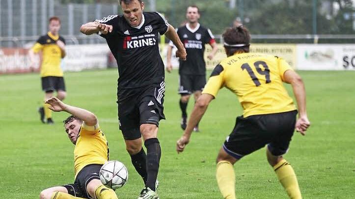 Mit einer Grätsche kann der Frohnlacher Spielführer Christopher Autsch (gelb) den Gäasteangreifer Thosten Schlereth vom Ball trennen; Nutznießer ist Daniel Alles (Nummer 19). Foto: Heinrich Weiß