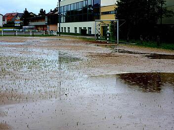 Auch gestern war der Nebenplatz im Sander Seestadion (im Hintergrund die Turnhalle) von Wasserpfützen übersät und unbespielbar. An seiner Stelle soll ein Kunstrasenplatz entstehen. Die Sander bemühen sich um Fördergeld für ein "Multikulturelles Gemeindezentrum". Foto: ab
