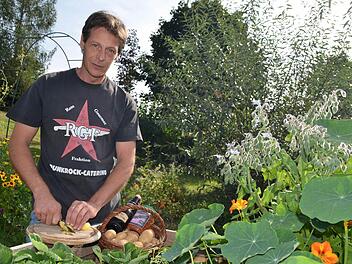 Martin Hartmann kocht gerne unkonventionell. Hier steht er im Garten von Sabine Sterker an einem Hochbeet, in dem neben Erdbeeren auch Kapuzinerkresse und Boretsch, im Volksmund auch Gurkenkraut genannt, gedeihen. Foto: Kathrin Kupka-Hahn