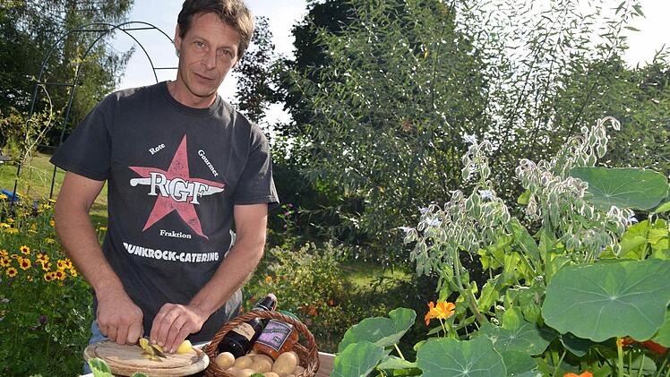 Martin Hartmann kocht gerne unkonventionell. Hier steht er im Garten von Sabine Sterker an einem Hochbeet, in dem neben Erdbeeren auch Kapuzinerkresse und Boretsch, im Volksmund auch Gurkenkraut genannt, gedeihen. Foto: Kathrin Kupka-Hahn