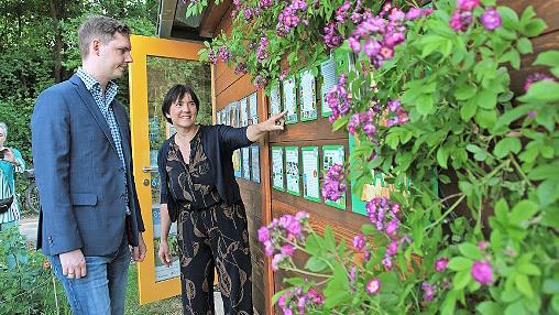 Ilona Munique stellt Zweitem Bürgermeister Jonas Glüsenkamp die neuen Schautafeln an der Bienen-Infowabe vor.