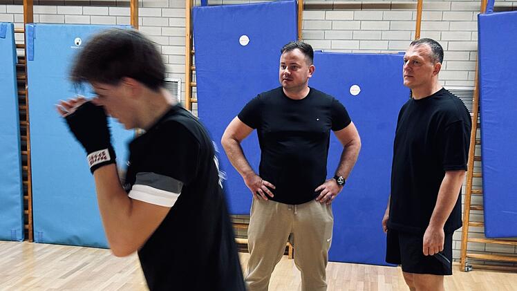 Der russischst&auml;mmige Boxer Vitali Litz (Mitte) und der ukrainische Kriegsfl&uuml;chtling Sergej Mermis (rechts) &uuml;berwachen das Training in Pirmasens gemeinsam.