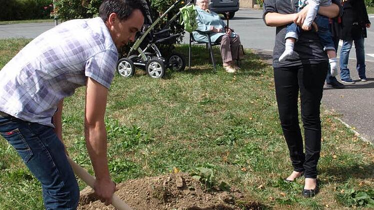 Während Marion Walter mit Sohn Jona zusieht, hebt Papa Stefan in Neuengrün das Pflanzloch für den Apfelbaum aus. Fotos: Susanne Deuerling