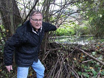 Der ehemalige Feuerwehrkommandant Benno Zellhan steht im Bett des Eschenbachs an einem Biberdamm. Er ist nur einer von mehreren Obereschenbachern, die mit dem aufgestauten Wasser durch Biberdämme zu kämpfen haben. Foto: Benedikt Borst/ Archiv