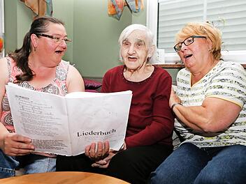 Das Singen ist ihre größte Freunde. Irmgard Schneider mit ihren Betreuerinnen Astrid Schneider (links) und Gerda Carroll (rechts) Foto: Matthias Hoch