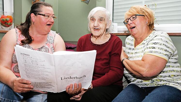Das Singen ist ihre größte Freunde. Irmgard Schneider mit ihren Betreuerinnen Astrid Schneider (links) und Gerda Carroll (rechts) Foto: Matthias Hoch
