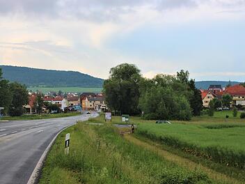Blick von Bad Kissingen kommend nach Nüdlingen: An der Kreuzung soll ein Kreisel kommen. Auf der Fläche rechts der Straße, zwischen dem Feldweg und den Häusern, soll ein Lebensmitteleinzelhandel entstehen.