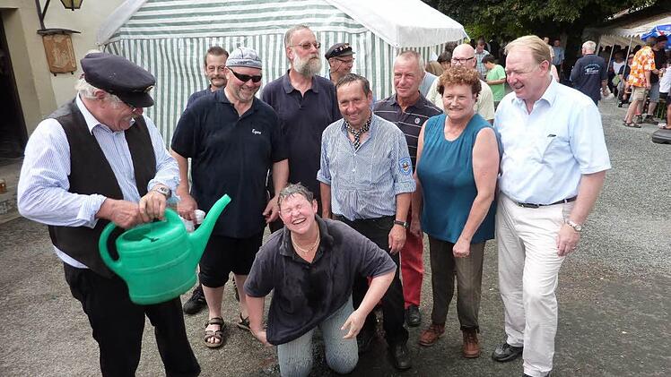 Genüsslich nahm Vorsitzender Friedrich Fricke die Flößertaufe mit Rodachwasser bei Kreiskulturreferentin Gisela Lang vor. Foto: Gerd Fleischmann