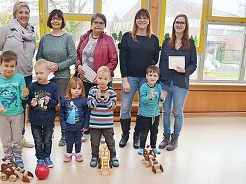 Spendenübergabe im Kindergarten St. Johannes der Täufer in Haßlach: Das Bild zeigt hinten, von links, Alexandra Wittmann (Sprecherin Muki- Gruppe), Kinderpflegerin Silvia Müller (Kita Haßlach), Claudia Baumann (Leiterin Kita Stockheim), Susanne Nickol (Muki-Gruppe) und Stefanie Bauer (Kita Neukenroth) mit einigen Kindern, die ihre Freude mit Beifall bekunden. Foto: Karl-Heinz Hofmann
