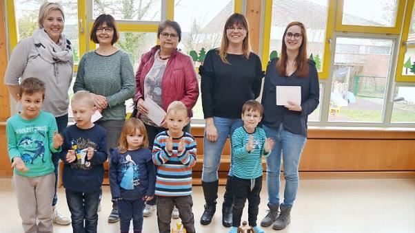 Spendenübergabe im Kindergarten St. Johannes der Täufer in Haßlach: Das Bild zeigt hinten, von links, Alexandra Wittmann (Sprecherin Muki- Gruppe), Kinderpflegerin Silvia Müller (Kita Haßlach), Claudia Baumann (Leiterin Kita Stockheim), Susanne Nickol (Muki-Gruppe) und Stefanie Bauer (Kita Neukenroth) mit einigen Kindern, die ihre Freude mit Beifall bekunden. Foto: Karl-Heinz Hofmann