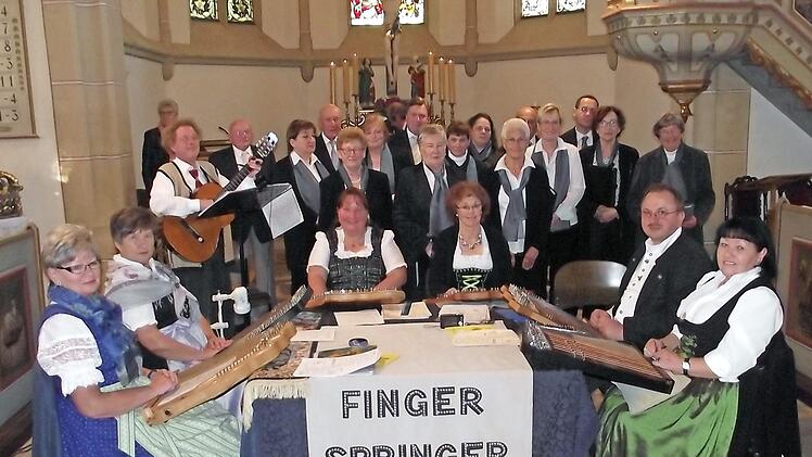 Die Akkordzither-Gruppe "Fingerspringer" mit (von links) Brigitte Brückner, Evi Hargens, Siggi Winkler, Christine Winkler, Renate Glaser, Heinrich Glaser und Veronika Petrat, sowie im Hintergrund der Kirchenchor Küps mit seiner Leiterin Hella Klumpp (rechts). Foto: Dieter Wolf
