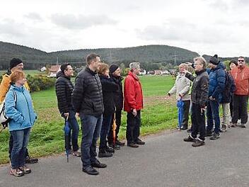 Bürgermeister Rainer Detsch zeigt auf die bestehende Stromtrasse (im Hintergrund) direkt in Haig. Mit im Bild der Freie-Wähler-Kreisvorsitzende Tino Vetter (links) und Stockheims Vorsitzender Stefan Häfner ( vierter von links). Foto: Karl-Heinz Hofmann