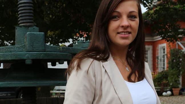 Die junge Frau posiert vor einer alten Weinpresse. Foto: Barbara Herbst