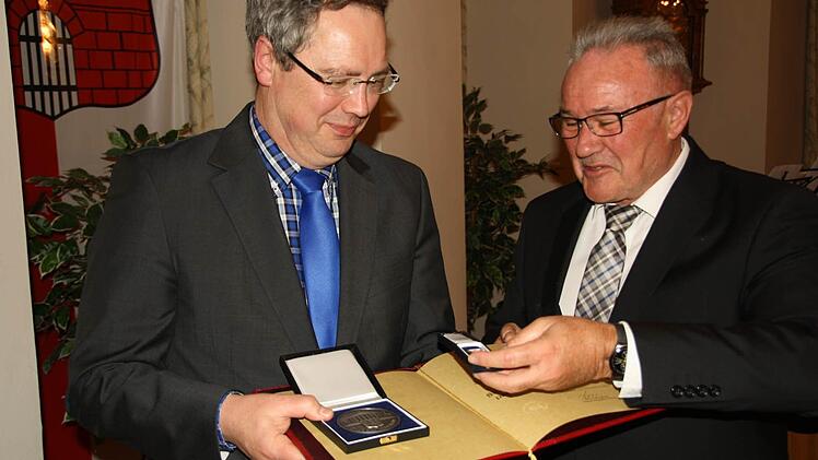 Pfarrer Jochen Wilde erhält von Bürgermeister Thomas Leiner die Silberne Bürgermedaille der Stadt. Foto: Paul Ziegler